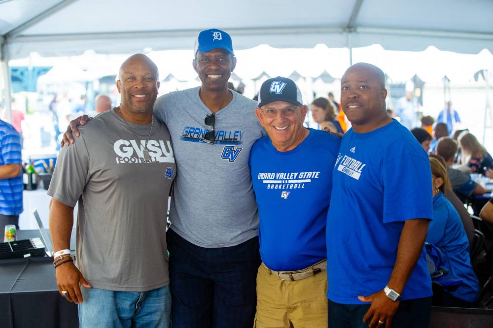 Group photo of four men wearing GVSU shirts at Comerica Park event